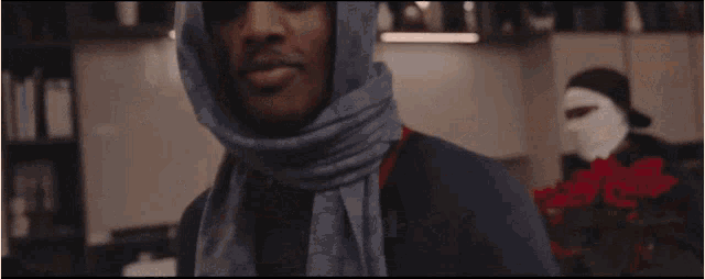 a man wearing sunglasses and a blue scarf around his head
