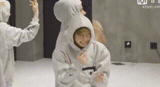 a person wearing a hoodie and a teddy bear costume is standing next to another person .