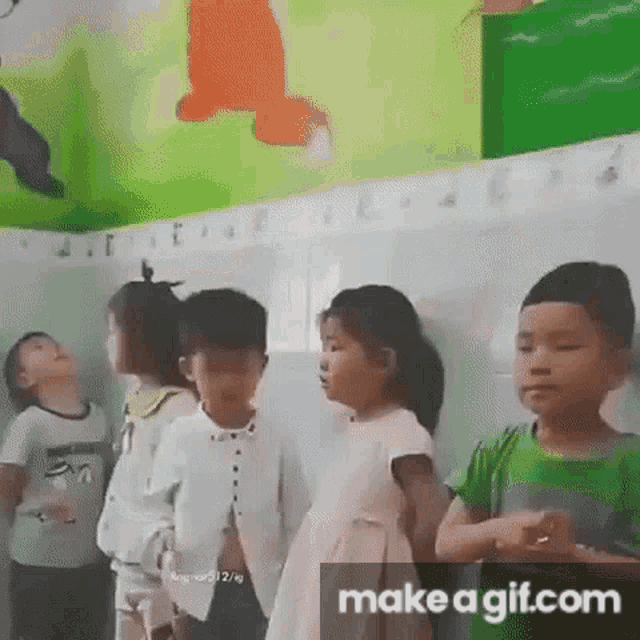 a group of children are standing in a bathroom .