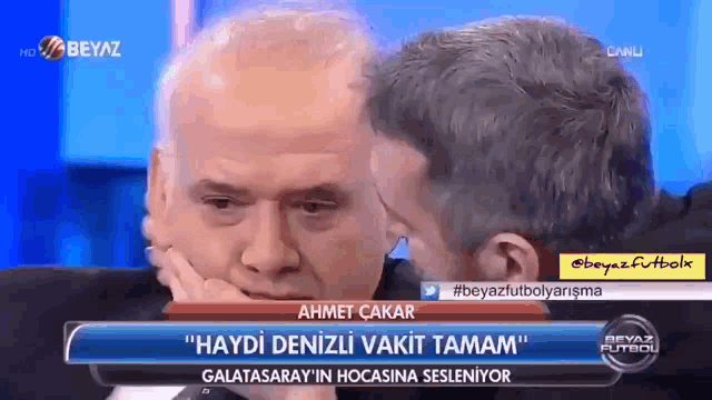 a man is being kissed on the cheek by another man on a television show