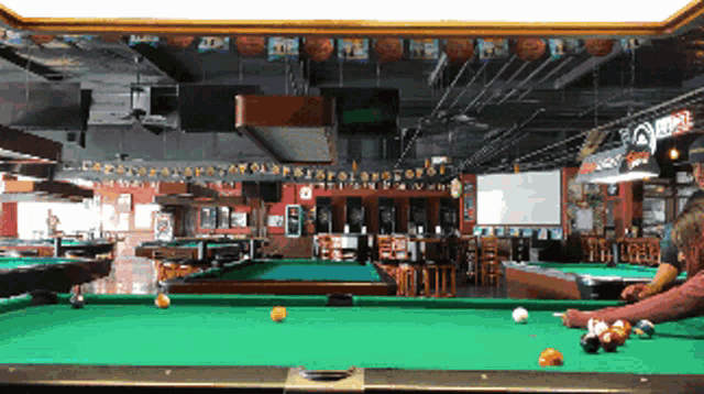 a pool table in a sports bar with a sign that says ' a ' on it