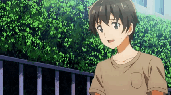 a young boy is standing in front of a fence .