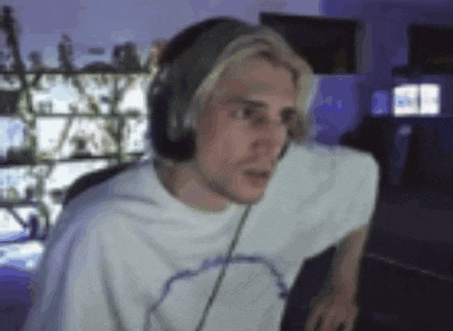 a man wearing headphones is sitting in front of a computer in a dark room .