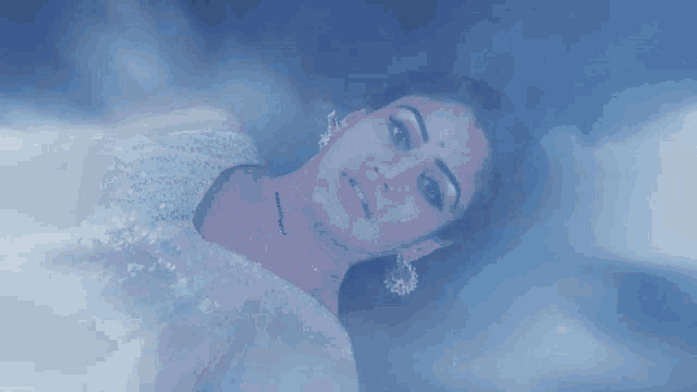 a woman in a white dress is floating in the air with her arms outstretched