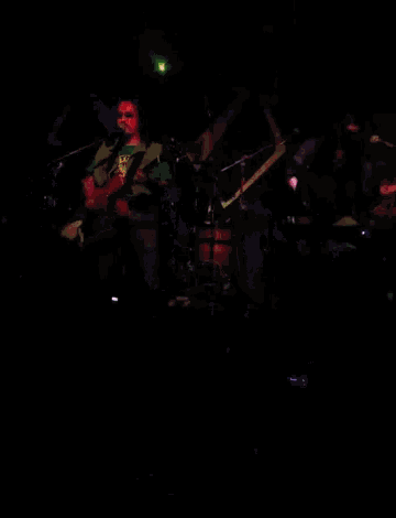 a man playing a guitar and another man playing a keyboard on a stage