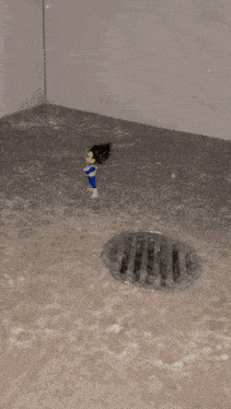 a toy figure is standing next to a manhole cover in a flooded room