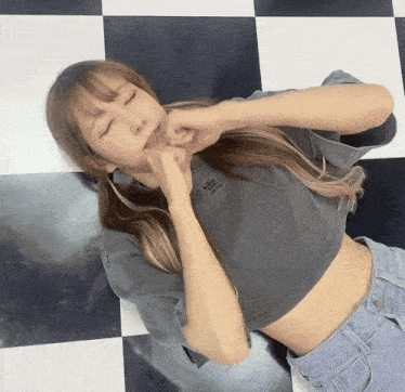 a woman wearing a grey adidas crop top lays on the floor