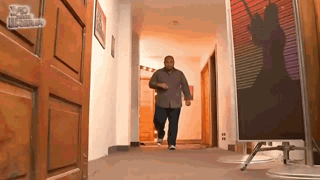 a man is walking down a hallway with a sign on the wall that says ' v8 ' on it
