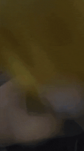 a blurred image of a person 's face with a yellow blanket in the background