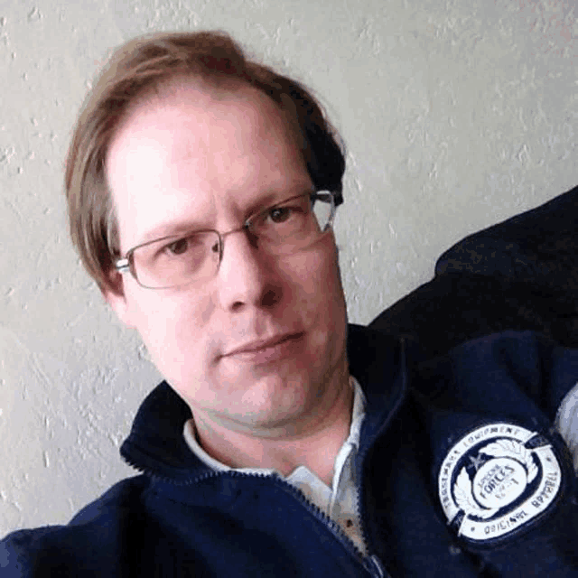a man wearing glasses and a blue jacket has a patch on his jacket that says ' force '