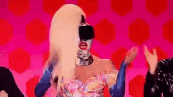 a woman with blonde hair and a mask on her face is dancing on a stage .