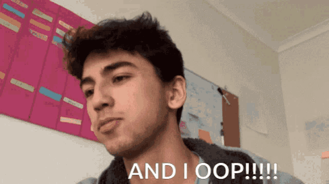 a young man says " and i oop !!! " in front of a pink board