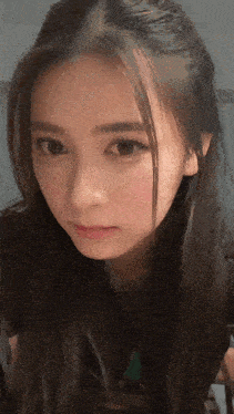 a close up of a woman 's face with a black shirt on