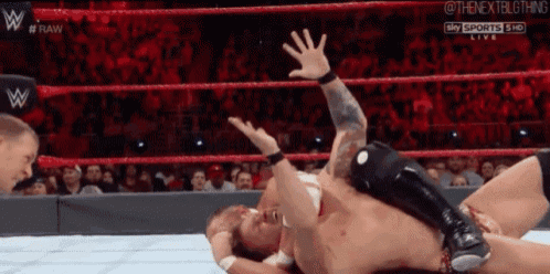 two men are wrestling in a wrestling ring with the words raw on the screen