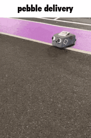 a pebble delivery robot is driving down a purple road .