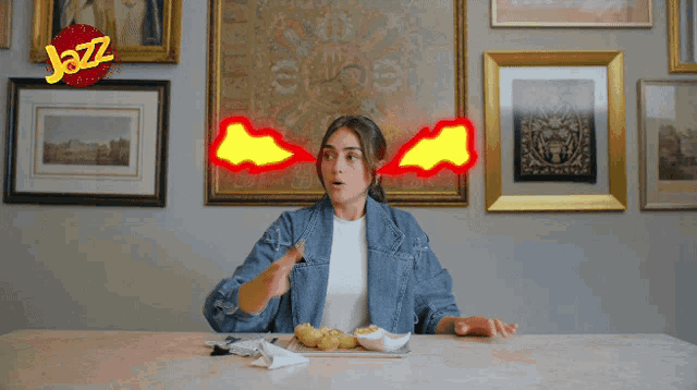 a woman sitting at a table with potatoes and a jazz logo above her head