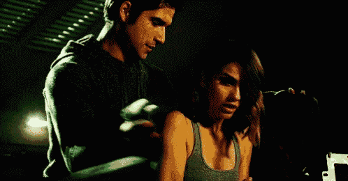 a man is standing next to a woman in a dark room .