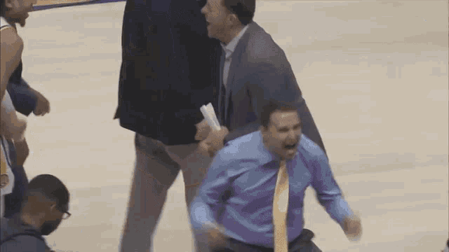 a basketball player wearing a number 9 jersey is being escorted by a man in a suit