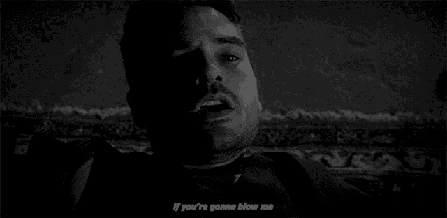 a man with a beard is laying on a rug in a black and white photo with a quote .