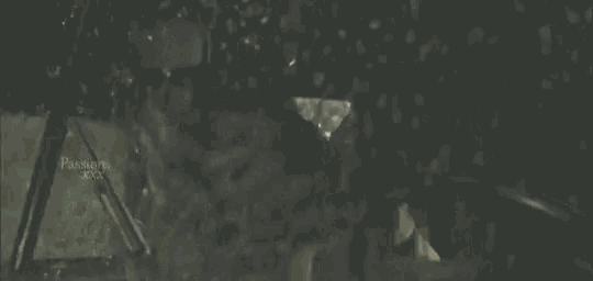 a person 's hand is reaching out towards a window while a car is driving in the rain .