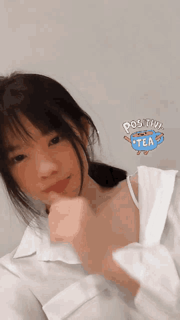 a girl wearing a white shirt has a positive tea sticker on her chest
