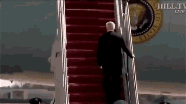a man in a suit is walking down a set of stairs .