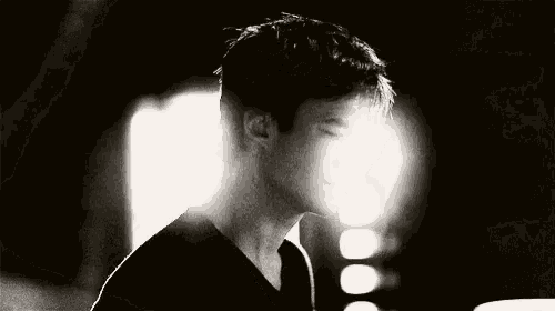 a black and white photo of a man in a dark room