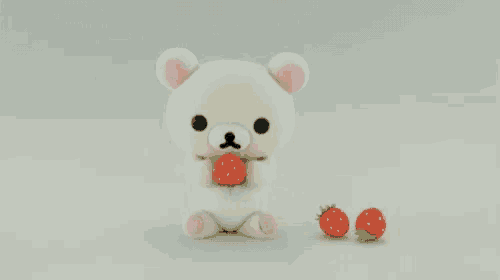 a white teddy bear is holding a strawberry in its hands