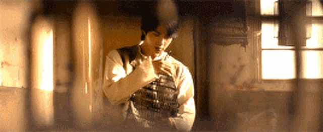a man in a white shirt is standing in a dark room