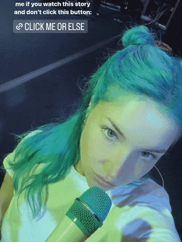 a woman with green hair is holding a microphone with a button that says click me or else