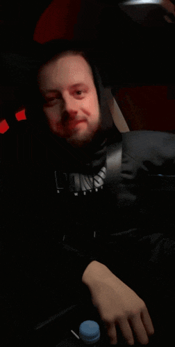 a man wearing a black shirt that says ' arizona ' on it is sitting in a car