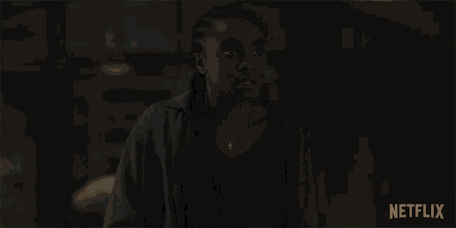 a woman is standing in a dark room and says " oh "