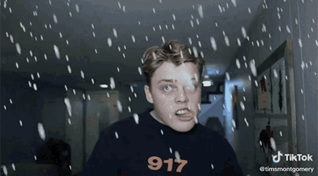a man wearing a shirt that says 917 is standing in the snow