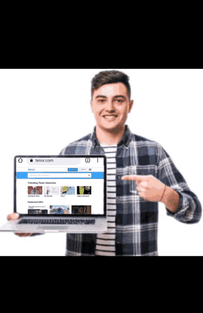 a man is holding a laptop with the website tenor.com on the screen