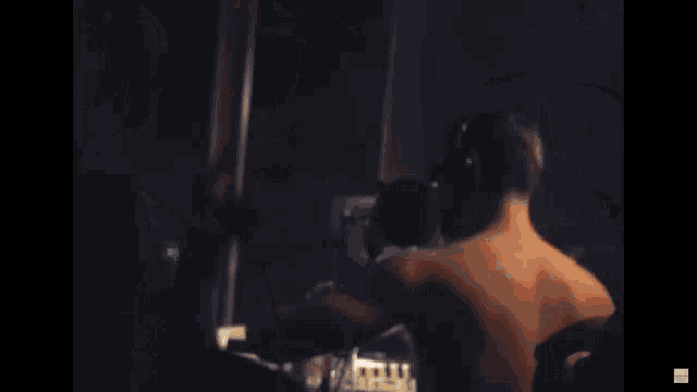 a man wearing sunglasses is singing into a microphone while wearing headphones