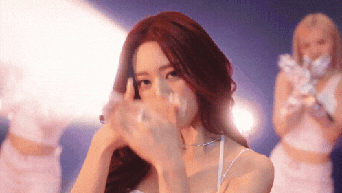 a woman with red hair covering her face with her hands