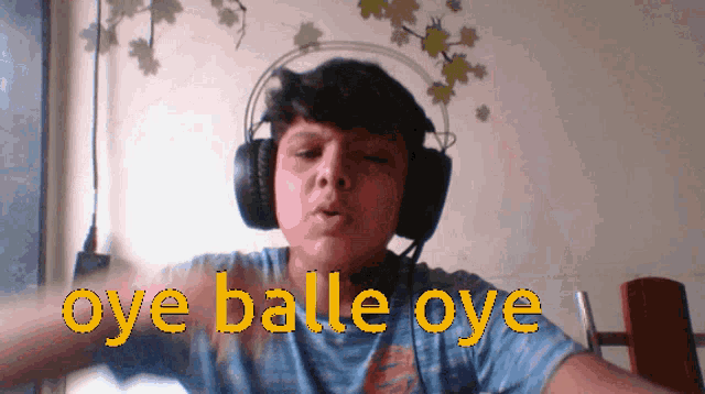 a boy wearing headphones says " oye balle oye " in yellow letters