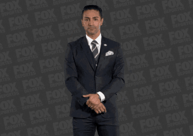 a man in a suit and tie stands in front of a fox advertisement