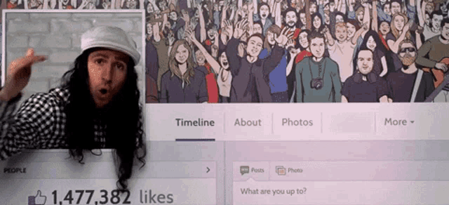 a man with long hair is standing in front of a facebook page with 1,477,382 likes