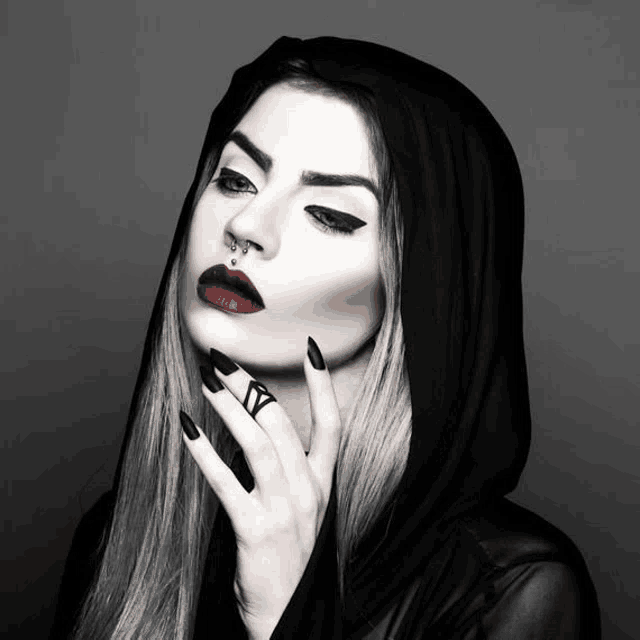 a woman wearing a black hood has a nose ring