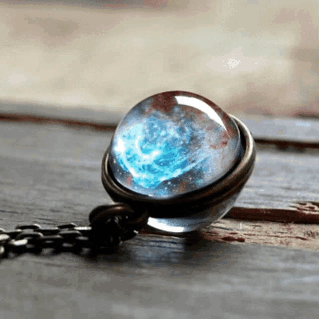 a necklace with a pendant that looks like a galaxy