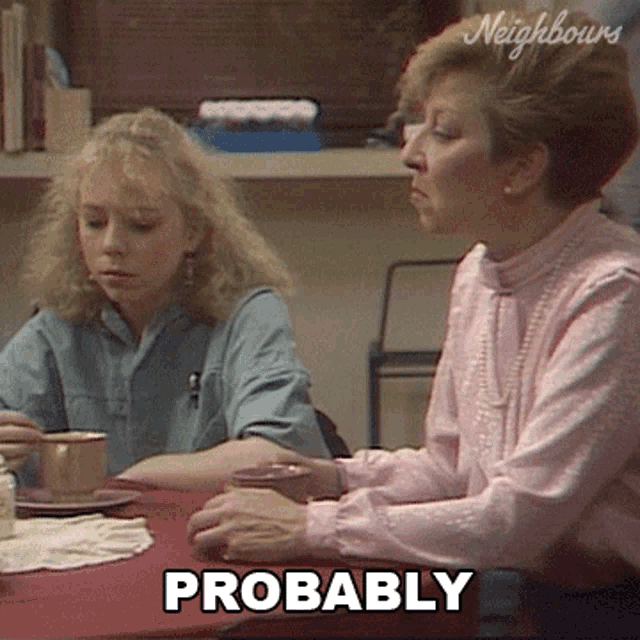 two women sit at a table with probably written on the bottom right