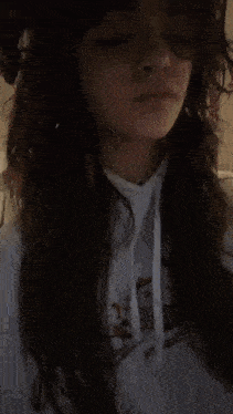 the girl is wearing a white hoodie and a necklace .