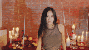 a woman is standing in front of a table with candles and balloons