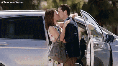 a man and a woman are kissing in the back of a car .