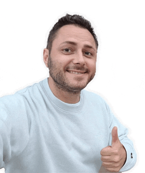 a man wearing a light blue sweatshirt gives a thumbs up