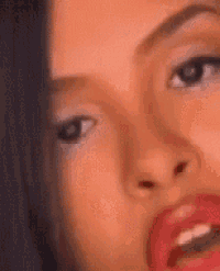 a close up of a woman 's face with red lips and a surprised look on her face .