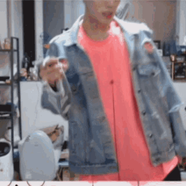 a man wearing a denim jacket and a pink shirt