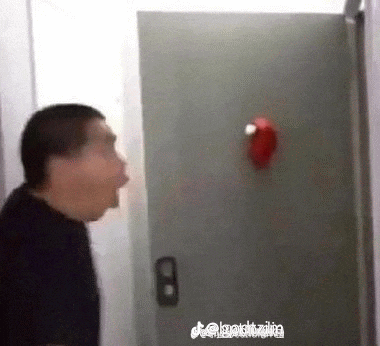 a man in a black shirt is standing in front of a door with his mouth open .