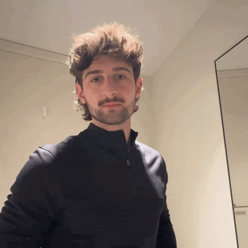 a man with a beard and mustache wearing a black shirt
